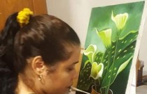 Mulher deficiente pinta com a boca na exposição virtual